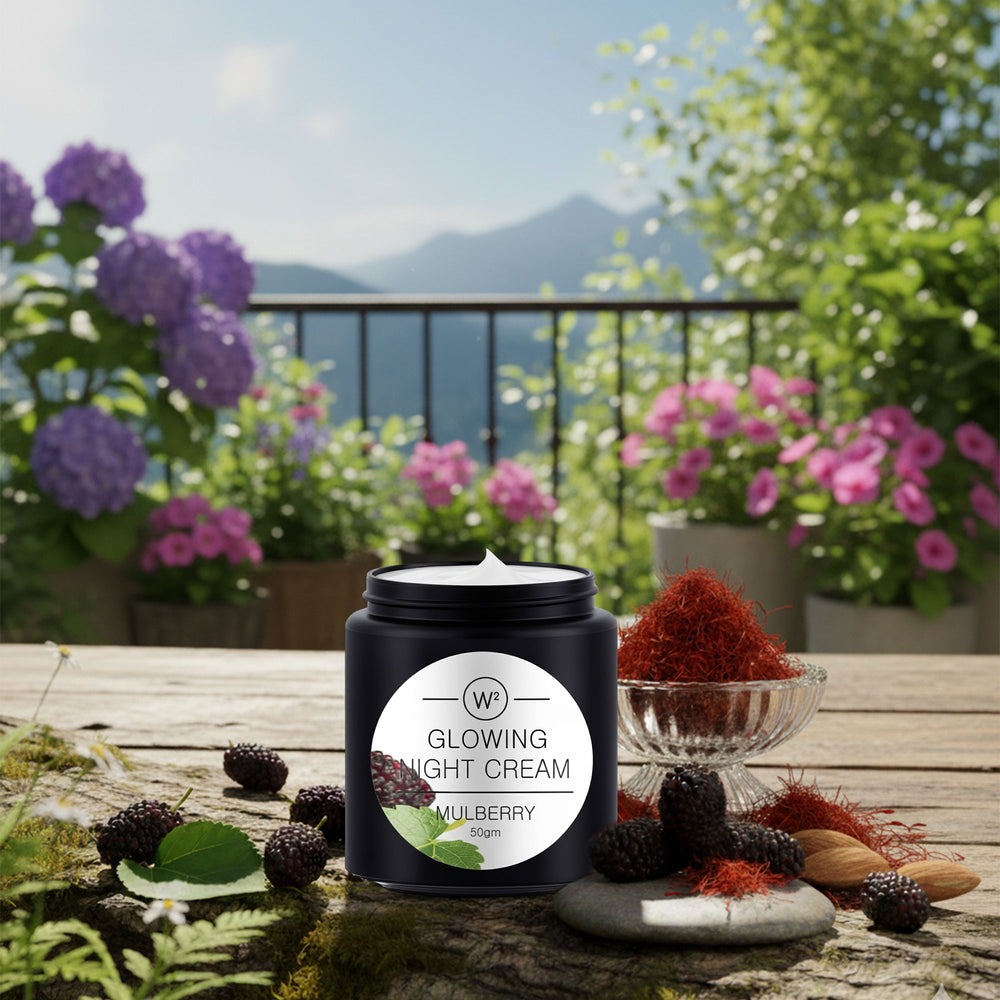 Glowing Night Cream container with mulberry ingredients on a wooden table with flowers and mountains in the background