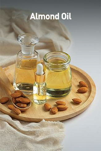 Almond oil in glass containers with almonds on a wooden tray