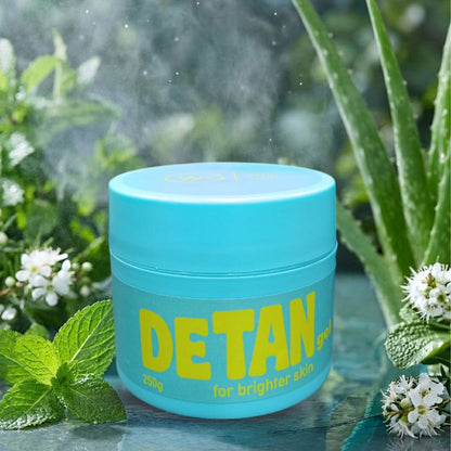 Blue jar labeled 'DETAN' with greenery in the background