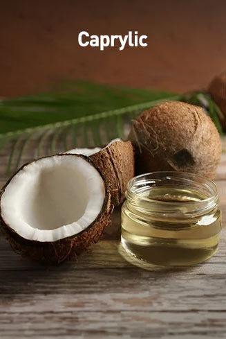 Coconut and a small jar of caprylic oil on a wooden surface with a leaf.